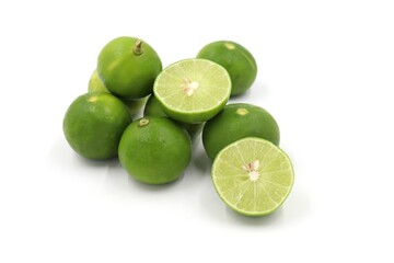 pile of fresh green lemons on white background
