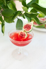 Red drink with ice. Alcoholic beverages decorated with fresh fig fruits on white background. Campari aperol drink