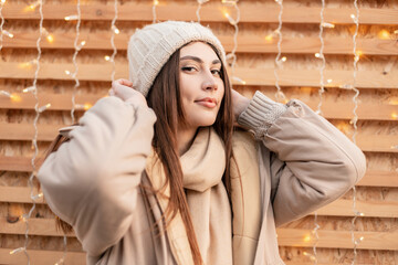 Pretty young girl in fashionable winter outwear with a knitted vintage slipper, a fashion...
