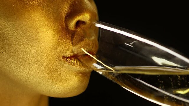 Female With Golden Skin Drinking Champagne Over Black Background, Closeup