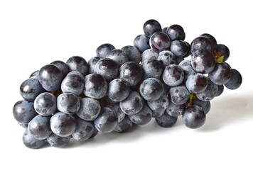 A large bunch of black grapes with sweet fruit on a white background.