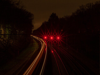 Long exposed railroad train at night with red light trails