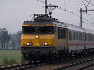 Fototapeta na wymiar Dutch yellow train with German wagons