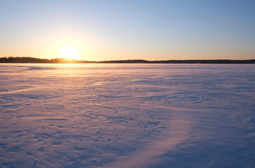 Obraz premium Beautiful sunset over a snowy field.