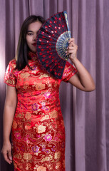 China Girl,Chinese woman red dress traditional cheongsam ,close up portrait with cloth backdrop