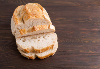 A homemade crusty loaf of bread on dark background