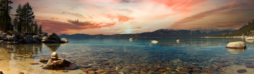 Panoramic mountain landscape scene in Lake Tahoe California with a colorful sunset in the background