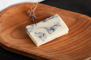 Handmade soap with dried lavender on rustic wooden background.