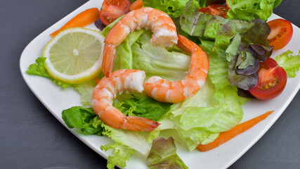 Healthy vegetable and shrimps salad of fresh tomatoes,lettuce,carrot on plate. Diet menu.