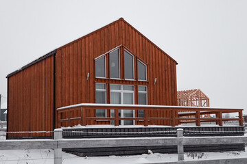 Fototapeta premium Modern wood house in the Scandinavian style with different color , winter day in village