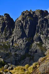 Detail of the Agulhas Negras peak (2.791m), one of the highest in Brazil, towering above the boulder-filled high sector of Itatiaia National Park, Itatiaia, Rio de Janeiro, Brazil