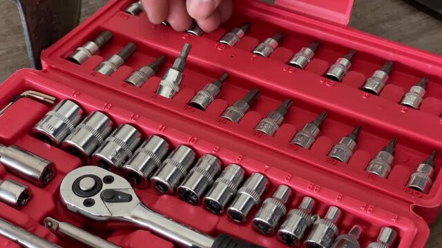 Close Up A man's hand is selecting a screwdriver in a red box set.