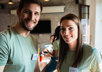 Portrait of two volunteers with working in community charity donation center.