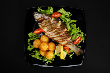 Trout baked The tenderest trout is baked with oyster sauce, garnished with potato rosettes and fresh vegetables