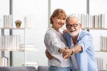 Obraz premium senior couple, elderly man and woman dancing together at home
