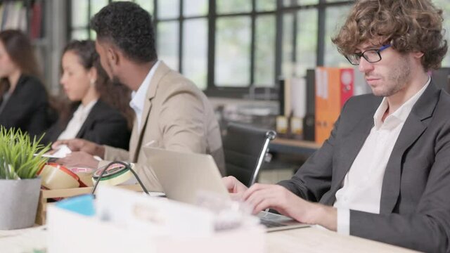 Two male coworkers in the office conversing and working together at work, happy businessmen teammates discussing computer business project brainstorming in corporate teamwork