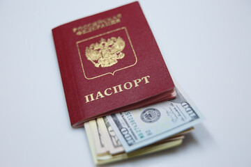 passport on the table with hundred-dollar bills inside the passport