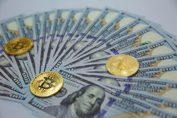 Gold bitcoins on US dollars for background. Bitcoin digital currency close-up. A new concept of virtual money. fall of bitcoin