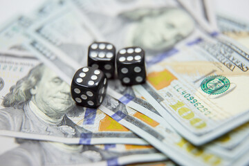 casino, gambling and fortune concept - close up of black dice and dollar cash money