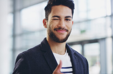 I've got this. Cropped shot of a young businessman showing winking and showing thumbs up while...