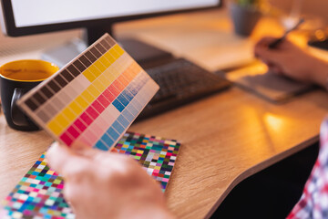 Fototapeta premium Designer choosing color from color pallete while working