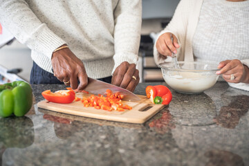 Mid section of couple preparing food in kitchen