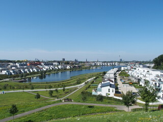 View of Phoenix Lake in the Dortmund suburb of Hoerde, North Rhine-Westphalia, Germany, a renatured industrial wasteland, in the background right the Dortmund TV tower, left the steeples of churches