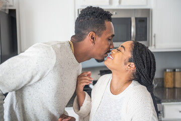 Fototapeta premium Smiling couple kissing in kitchen