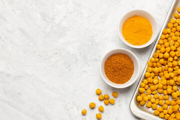 Indian traditional spices curry powder, garam masala and turmeric for roasting chickpeas on a baking tray. Flat lay, top view