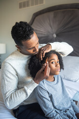 Father combing sons  hair in bedroom