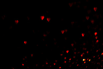 Red hearts, blurred bokeh lights on black background. Glitter sparkle for valentines day. Overlay...