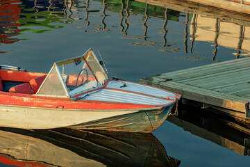 old motor boat moored to the pier. boat on the water in the summer