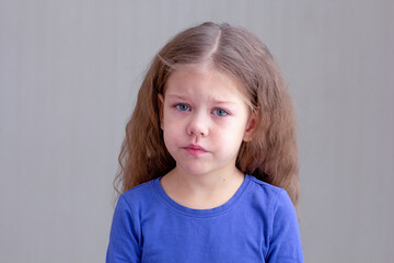 Sad and unhappy child kid with tears of distress, pain or sorrow on gray background looking at...