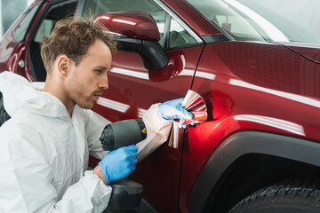 Professional auto painter matches car paint color with lamp and samples