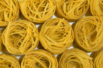 Italian pasta. Spaghetti Capellini isolated on white background, top view. Pasta in the form of nests. pattern