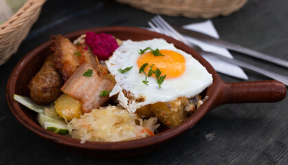 Breakfast of scrambled eggs with fried bacon and potatoes