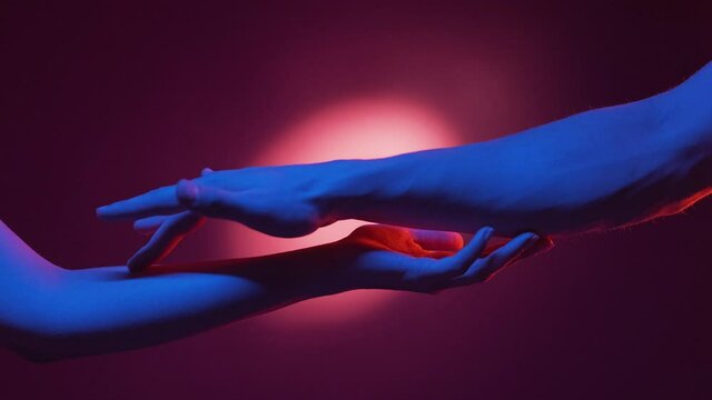 First date. Sensual hands. Neon light portrait. Seductive male and female arms getting know touching each other on red blue halo spotlight background.