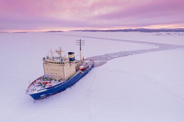 Icebreaking vessel in Arctic with background of sunset - obrazy, fototapety, plakaty