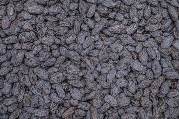 Black dried grapes background. Delicious healthy food.