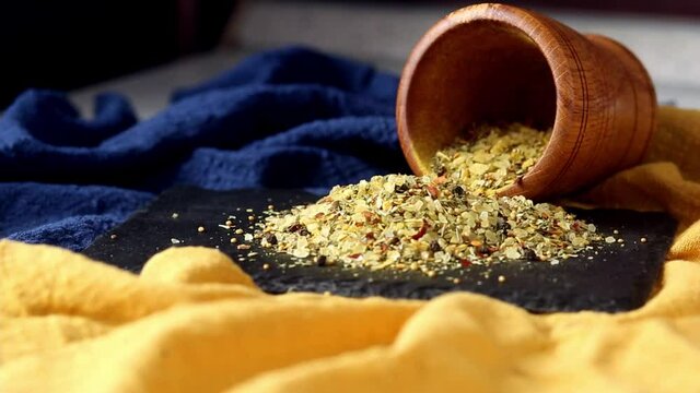 Sweep spices and herbs scattered from a mortar on a black board. Spicy, spicy, salty. Add flavor to food while cooking