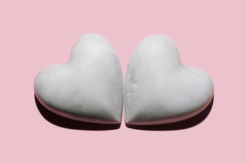Obraz premium Two concrete/plaster hearts on pastel pink background. Minimalist Valentines Day Concept. Love background.