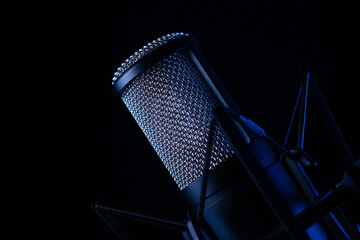 studio black condenser microphone on black background