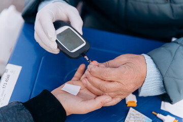 doctor measures blood glucose in patient with diabetes 