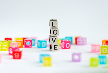 The word LOVE laid out in silver cubes among colored