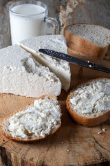 Slices of bread topped with fresh curd cheese and a glass of milk.