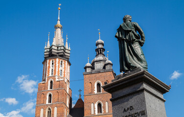 Famous Saint Mary's Basilica (Mariacki Church Kraków) and Adam Mickiewicz Monument at the Main Market Square in the Old Town district of Krakow, Poland.
