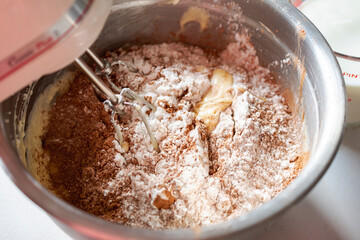 Making of a chocolate cake:  Adding dry ingredients.  Mixer beaters stationary.