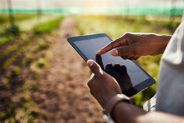 The farm at his fingertips. Cropped shot of an unrecognizable male farmer using a tablet while working on his farm.