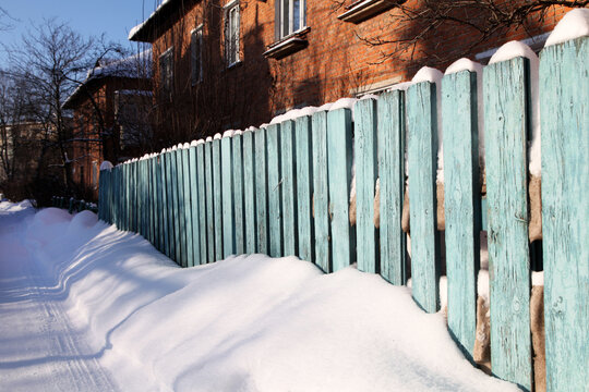 Snowdrift Under A Wooden Fence, Winter Scene Without People