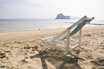 Relax foldable beach chair on sandy seashore in sunny day